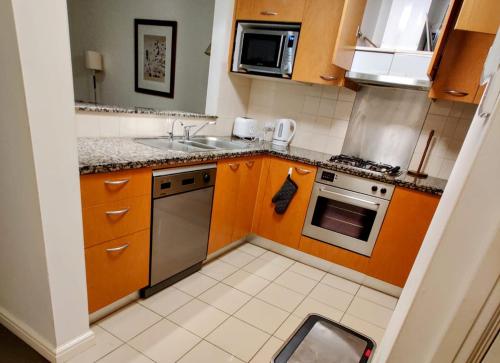 a small kitchen with a sink and a stove at Shared apartment in Regency Hyde Park in Sydney