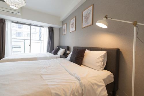 Postel nebo postele na pokoji v ubytování Unizen道顿堀店