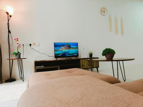 a living room with a couch and a flat screen tv at SoulHealingPlace Galacity 2BR 2Bed Apartment in Kuching