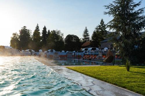 a pool at a resort with tables and chairs at Kamengrad Hotel & SPA in Panagyurishte