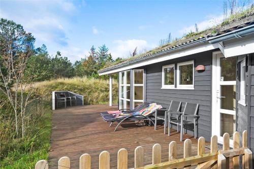 a wooden deck with chairs and a house at BL1678-Pandrup-Hunetorp-Klitvej-1-B in Pandrup