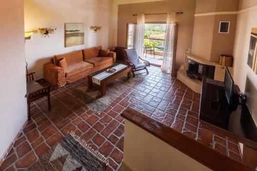 a living room with a couch and a tv at Hotel Epavlis in Káto Poróïa