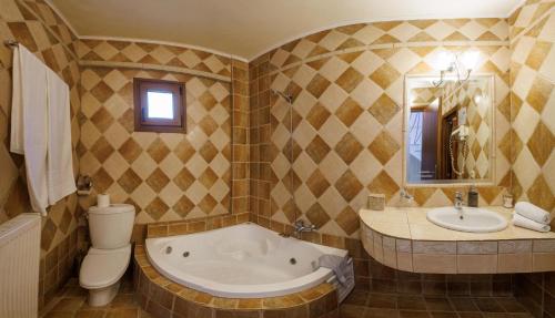 a bathroom with a tub and a toilet and a sink at Hotel Epavlis in Káto Poróïa