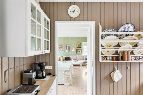 a kitchen with a counter and a clock on the wall at BL1612-Blokhus-Jens-Baerentsvej-3 in Blokhus