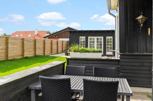 a patio with a table and chairs and a fence at BL1612-Blokhus-Jens-Baerentsvej-3 in Blokhus