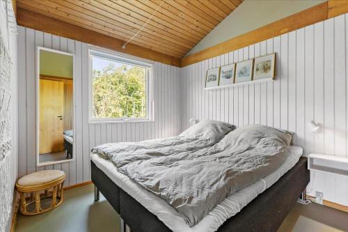 a bedroom with a bed in a room with a window at BL1728-Blokhus-Kaeruldvej-7 in Blokhus