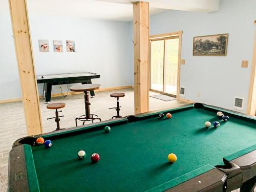 a room with a pool table with balls on it at Luxury Log Cabin Lakefront, Game room & Fire Pit, in Schenevus