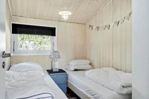a bedroom with two beds and a window and a lamp at BL1546-Saltum-Stenrev-6 in Saltum
