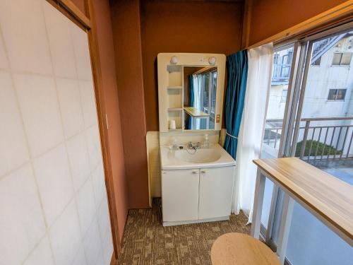 a bathroom with a sink and a mirror and a window at Guest House HIIRAGI in Yamanakako
