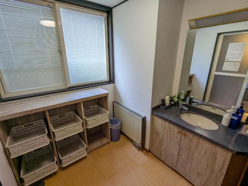 a bathroom with a sink and a large window at Guest House HIIRAGI in Yamanakako