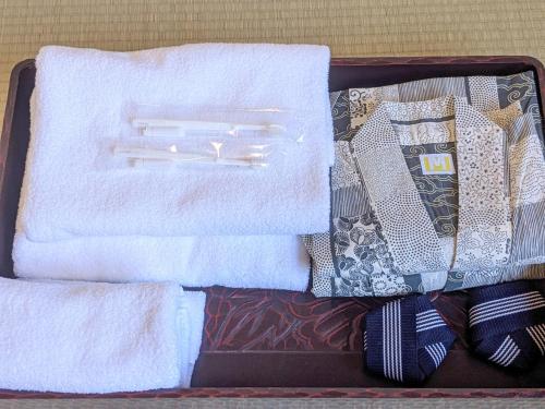 a suitcase with towels and toothbrushes and towels at Guest House HIIRAGI in Yamanakako
