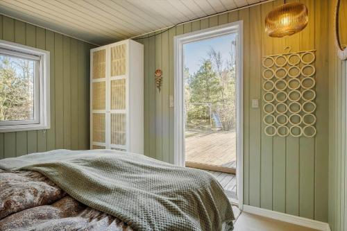a bedroom with a bed and a large window at BL1458-Blokhus-Lyngmarken-6 in Blokhus