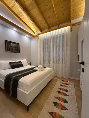 a bedroom with a large bed and a window at Villa REJA Hamallaj in Draçi