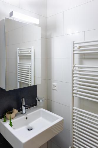 a white bathroom with a sink and a mirror at Anatas in Saas-Fee