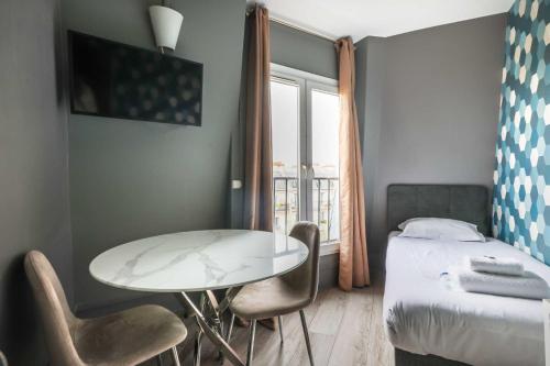a bedroom with a table and chairs and a bed at Modern studio - 1P- Canal Saint-Martin in Paris