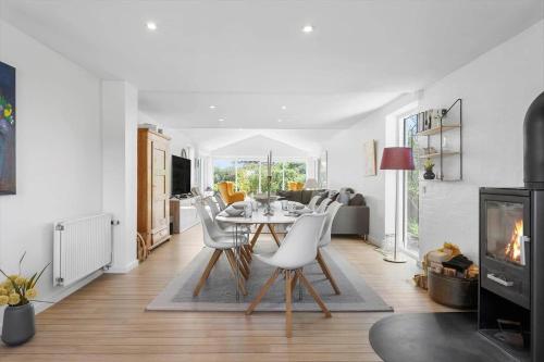 a living room with a table and chairs and a fireplace at BL509-Blokhus-Jens-Baerentsvej-7 in Blokhus