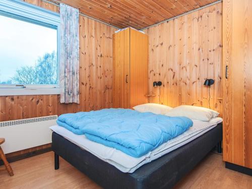 a large bed in a room with wooden walls at 6 person holiday home in Fårvang in Fårvang