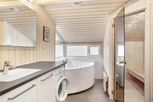 bagno con vasca, lavandino e lavatrice di BL377-Blokhus-Maxvej-9 a Blokhus