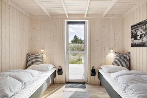 due letti in una stanza con finestra di BL377-Blokhus-Maxvej-9 a Blokhus