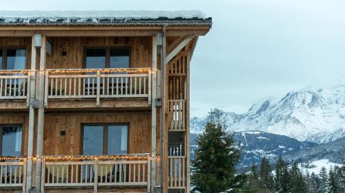 a log building with a view of the mountains at Chalet Alpen Valley, Mont-Blanc in Combloux