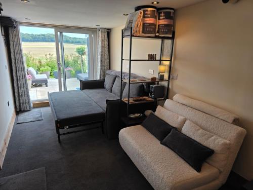 The Pod Quiet Sun Patio Fab Steam &Countryside Views في ويبورن: غرفة معيشة مع أريكة وكرسي