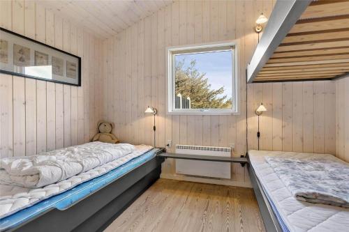 a bedroom with two beds and a window at BL819-Blokhus-Pirupshvarrekrogen-2 in Blokhus