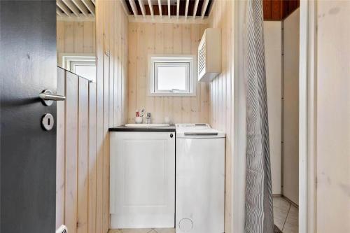 a small bathroom with a sink and a washer at BL819-Blokhus-Pirupshvarrekrogen-2 in Blokhus