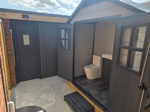 The Pod Quiet Sun Patio Fab Steam &Countryside Views في ويبورن: حمام صغير مع مرحاض وباب