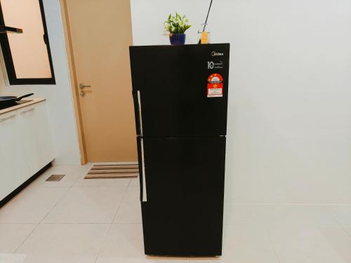 a black refrigerator in a kitchen with at SoulHealingPlace Galacity 2BR 2Bed Apartment in Kuching