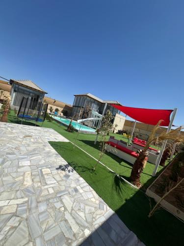 a garden with trees and a building with a red roof at the royal occasion amman in Amman