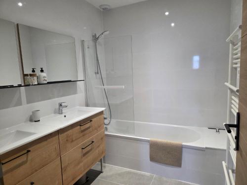 a bathroom with a tub and a sink and a shower at Le chalet du Petit Ours Brun in Formiguères