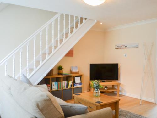 Una sala de estar con escalera y televisor. en Filey Central Two - Uk42903, en Filey