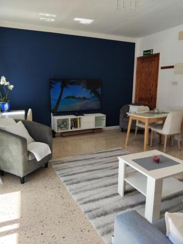 a living room with a blue accent wall at Apartment close to the beach, fully equipped, unique and cosy with balconies in Is-Sellum