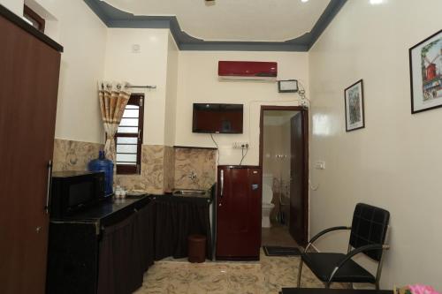 a room with a kitchen with a door and a chair at Atithi Home Stay- Studio Room in Udaipur