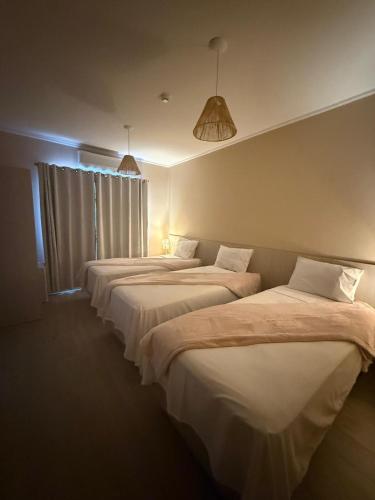 a row of three beds in a room at Pousada Maritaca in Bonito