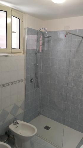 a bathroom with a shower with a toilet and a sink at Hoya Room & Living in Bari