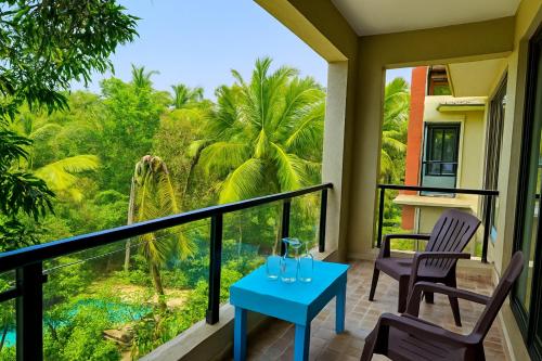 a balcony with two chairs and a blue table at 1 bhk Home Palolem Beach in Canacona