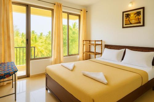 a bedroom with a bed and a large window at 1 bhk Home Palolem Beach in Canacona