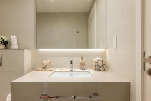 a bathroom with a sink and a mirror at Beach Please in Dubai