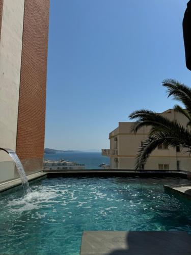 a swimming pool with a fountain in a building at k&k apartament in Sarandë
