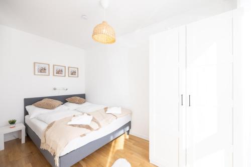 a white bedroom with a bed with white walls at Deluxe Apartment with garden! Near SCS & Industry Center NÖ in Wiener Neudorf