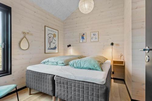 a bed in a room with wooden walls at BL1433-Blokhus-Mollevej-11 in Blokhus