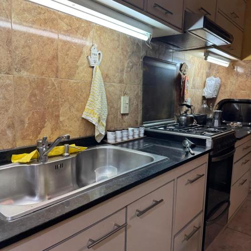 a kitchen with a sink and a stove at Casa 2 hab, cerca del centro y costanera in Gualeguaychú