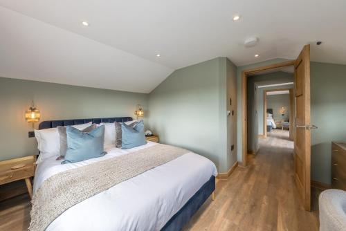 Un dormitorio con una cama grande con almohadas azules. en Ysgubor-Cerbyd, en Amroth