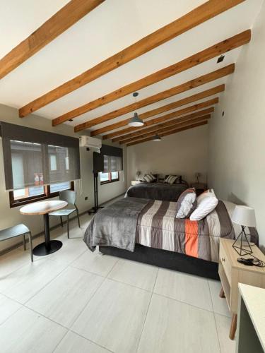 a bedroom with a large bed and a wooden ceiling at Microdepartamentos Chillán in Chillán