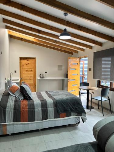 a bedroom with a bed and a table and a desk at Microdepartamentos Chillán in Chillán