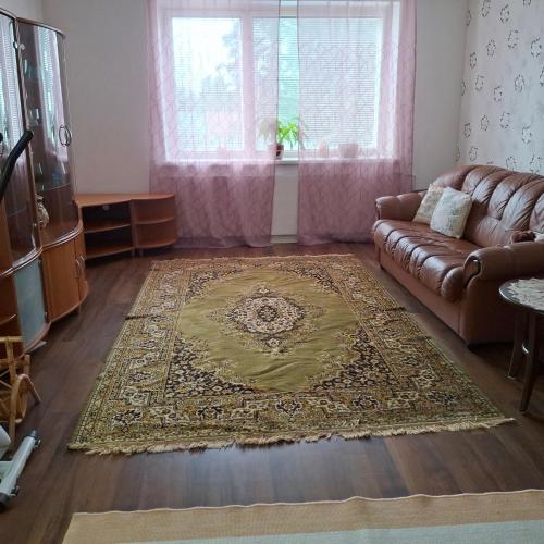 un soggiorno con un divano e un tappeto di Kontiopuisto a Pieksamaki