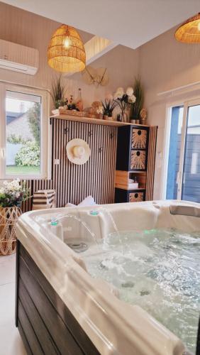 a large bath tub in a room with at Sweety Loft Suites romantique avec jacuzzi in Friville-Escarbotin