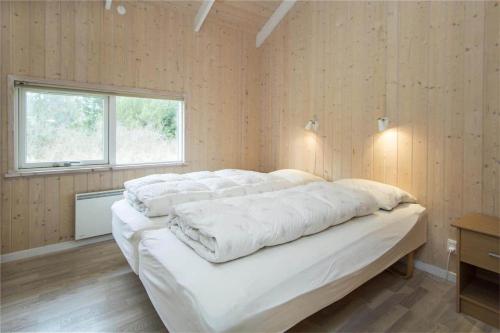 a large white bed in a room with a window at BL481-Pandrup-Rodhusparken-10 in Pandrup