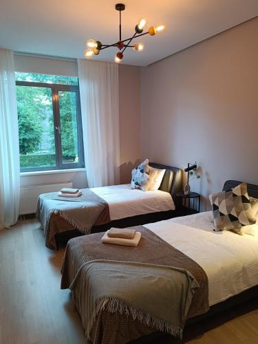 a room with three beds and a window at First Line - Dzintaru prospekts Apartment in Jūrmala